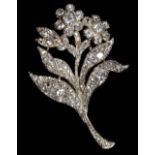 A yellow and white metal diamond floral brooch, set with 135 old cut diamonds varying in size with a