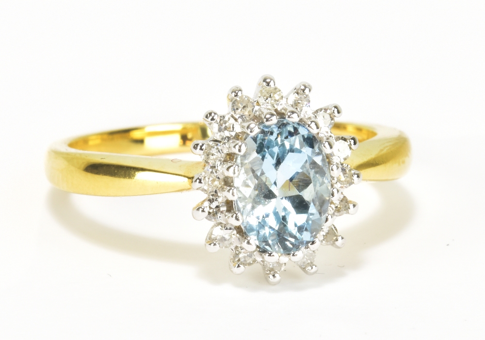An 18ct yellow gold aquamarine and diamond floral cluster ring, the oval aquamarine weighing
