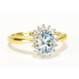 An 18ct yellow gold aquamarine and diamond floral cluster ring, the oval aquamarine weighing
