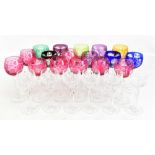 Twenty-three Bohemian style coloured cut glass wine glasses and six clear moulded glasses (29).