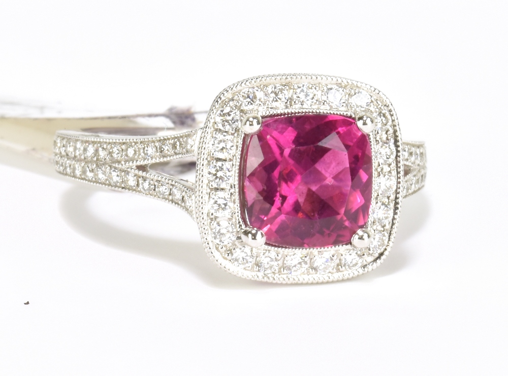 An 18ct white gold diamond and rubellite ring with pierced shoulders and raised platforms, size N,