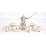 An Egyptian white metal teapot with hinged lid and six tea bowls, all with bright cut stylised