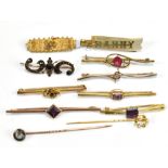 A group of eleven gold and yellow metal brooches and stick pins.