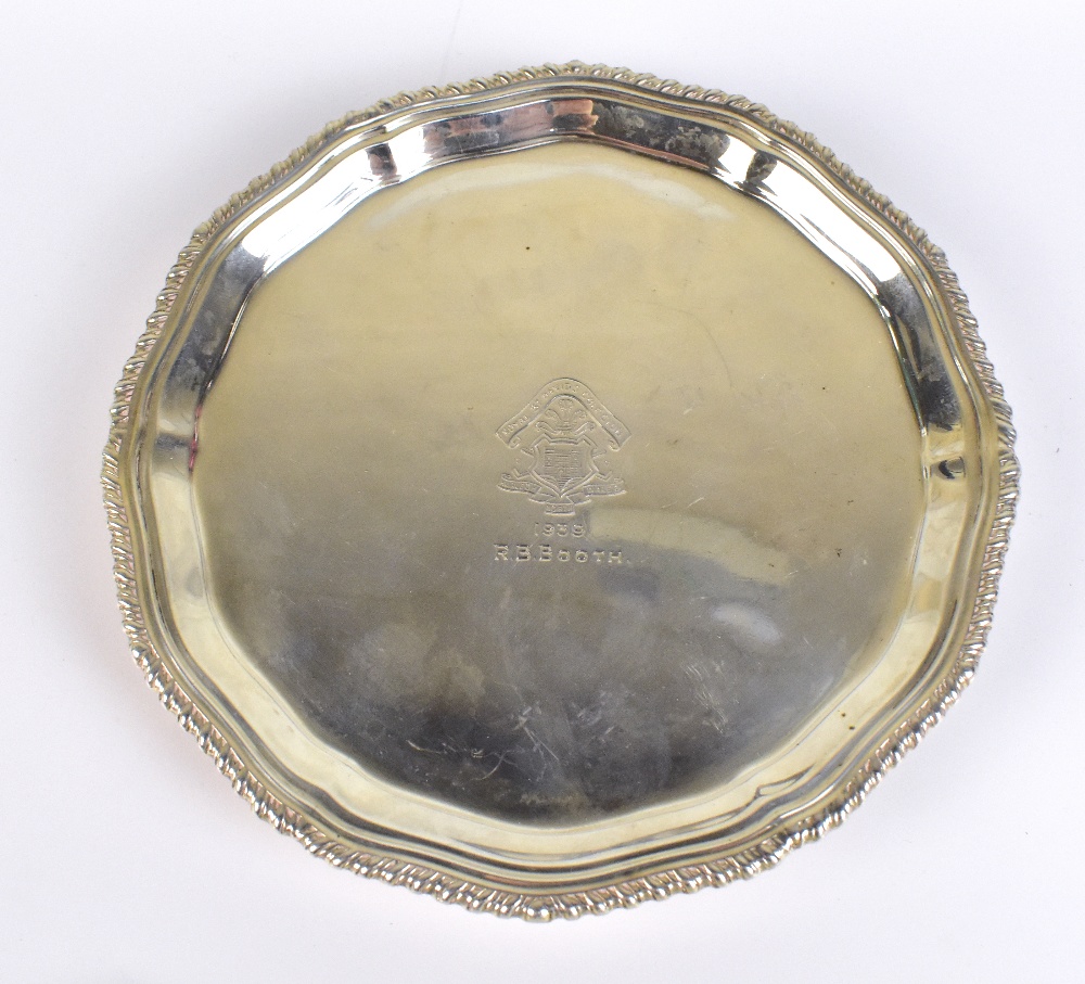 A George VI hallmarked silver waiter, with shaped rim and three scrolling supports, with