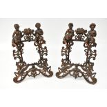 A pair of cast iron photograph frames, each decorated with figures above stylised beasts, 33 x