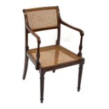 An early 20th century caned armchair.