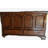 A late 18th/early 19th century oak blanket chest with panelled front above two short drawers on
