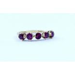 An 18ct gold ring set with five rubies in claw settings, stamped 750, size M, approx 2.5g.