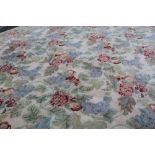 A large machine-made wool floral decorated cream ground carpet with floral border,