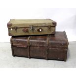 A large wooden bound trunk and a smaller green canvas suitcase (2).