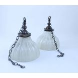 A pair of vintage ceiling mounted lights with vertical fluted off-white glass shades suspended by