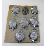 A board of eight plated Police helmet badges to include Leeds City Police helmet plate,
