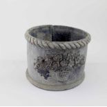 An early 20th century small circular lead planter with moulded vase of flowers and piecrust edge,