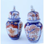 A pair of Meiji period Imari palette small baluster vases with covers,