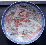 A large Japanese Meiji period Imari charger decorated with twin shaped panels within fish painted