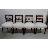 A set of four Edwardian mahogany bar-back dining chairs with stuff-over seats raised on reeded