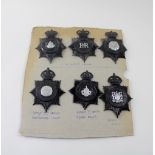 A board of six Police helmet badges, three pre-1953 and three post-1953.