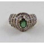 A 9ct yellow gold ring, marked 375, set with small baton diamonds and central emerald, size Q,