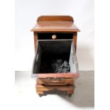 An Edwardian mahogany coal purdonium with fall front and raised on bracket feet to castors,