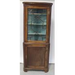 A George III mahogany floor-standing corner cupboard,