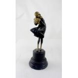 AFTER LORENZL; a bronze of a 1920s lady dressed in a coat and braced against the wind,