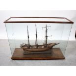 A scratch-built three-masted ship with Isle of Man insignia on wooden base in glazed display case,
