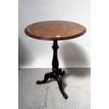 A Victorian walnut-topped occasional table raised on turned column to carved tripod base,