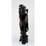 A large Japanese root wood carving depicting a wise man on stand inlaid with brass filigree wire,