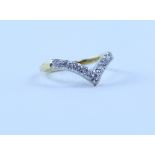 An 18ct gold wishbone ring set with nine diamonds in white metal, stamped 750, size P, approx 3.6g.