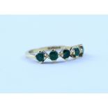 An 18ct gold ring set with five emeralds in claw settings, stamped 750, size N, approx 2.7g.