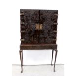 A mid-20th century locally hand-carved wooden cabinet with brass escutcheon and hinges,