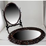 An oval mahogany dressing table swivel mirror and a 1920s bevel-edged oval wall mirror in an ornate