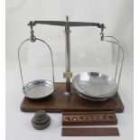 A set of scales with ivorine label and five graduated brass weights and a cased set of weights and