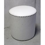 A contemporary leatherette-covered cylindrical foot stool with studded detail,