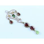 An Edwardian yellow metal openwork pendant set with garnets and peridot.