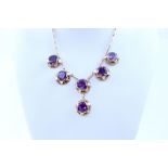 A Victorian yellow metal pendant necklace set with six amethyst.