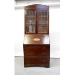 A 1930s bureau bookcase, the top with twin leaded glazed doors,