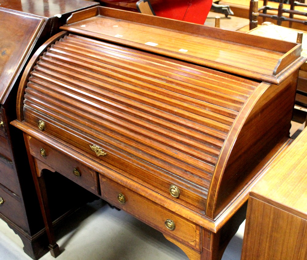 An Edwardian inlaid mahogany tambour-top writing desk with fitted interior above two short drawers,