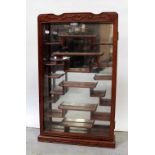 A 20th century Oriental hardwood wall-hanging display cabinet with glazed door and mirrored back,