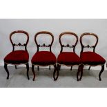 A set of four Victorian mahogany balloon-back dining chairs with upholstered stuff-over seats