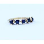 An 18ct gold ring set with five sapphires in claw settings, stamped 750, size L/N, approx 2.7g.