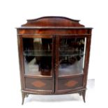 An early 20th century mahogany bow-fronted display cabinet with pair of glazed cupboard doors,