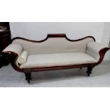 A Regency mahogany-framed settee of typical form with arched back and outswept arms,