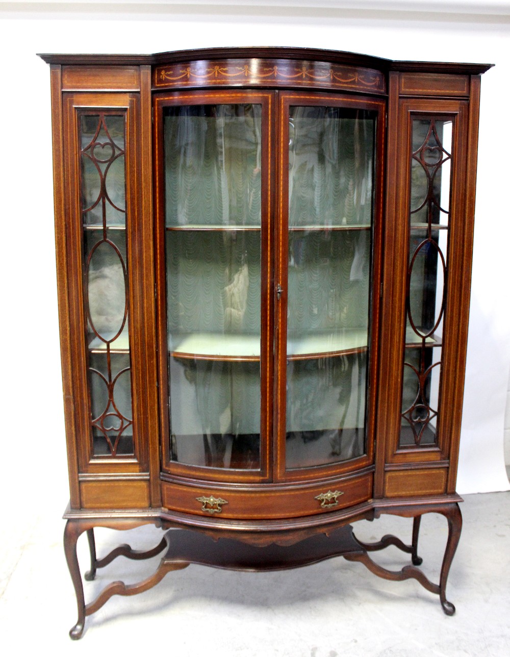 An Edwardian inlaid mahogany bow-fronted display cabinet inlaid with satinwood swags,