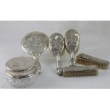 A six piece George V hallmarked silver backed dressing table set comprising two clothes brushes,