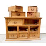 A modern stained wooden chest of drawers, two long and six short drawers, on a plinth base,