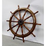 A large ship's wheel with inset brass ring and numbered to the central hub 493,