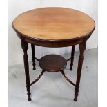 An Edwardian mahogany circular side table on turned and reeded supports with undershelf,