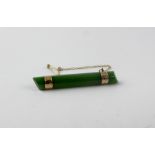 A jade bar brooch with yellow metal fittings, length 5.5cm.