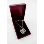 A yellow metal necklace with turquoise and seed pearl star pendant.